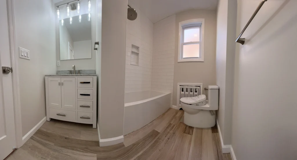 Full Bathroom Renovation with White Subway Tile Tub Surround, Marble-Top Shaker Vanity, and Wood-Look Porcelain Flooring in Union, Union County, NJ